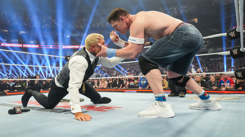 John Cena preparing to punch Cody Rhodes in the face with a Rolex on WWE Elimination Chamber