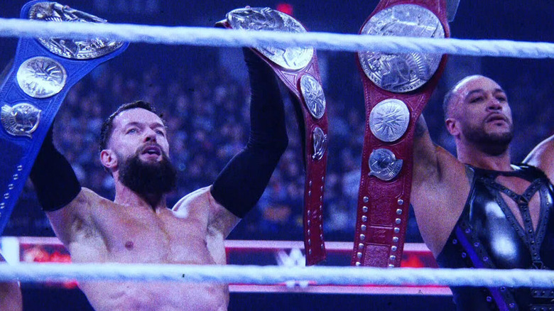 Finn Balor and Damian Priest post with the titles