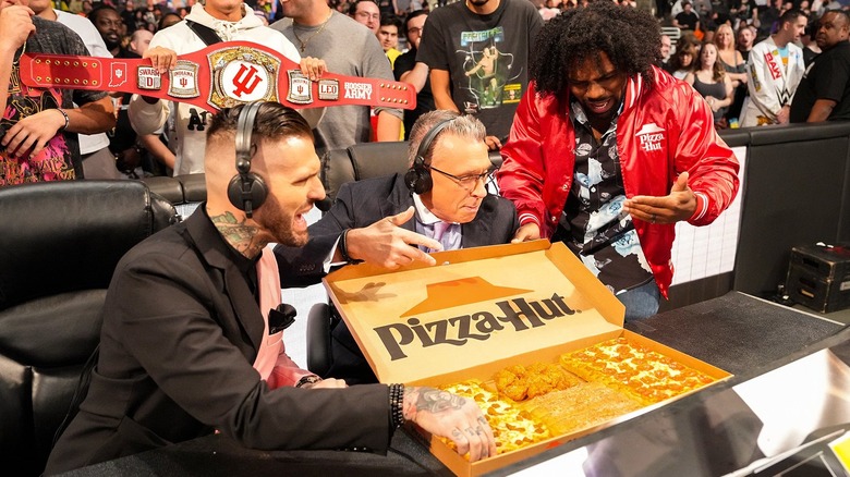 Corey Graves, Michael Cole, and Xavier Woods drool over pizza