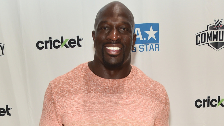 Titus O'Neil wearing a pink shirt and smiling