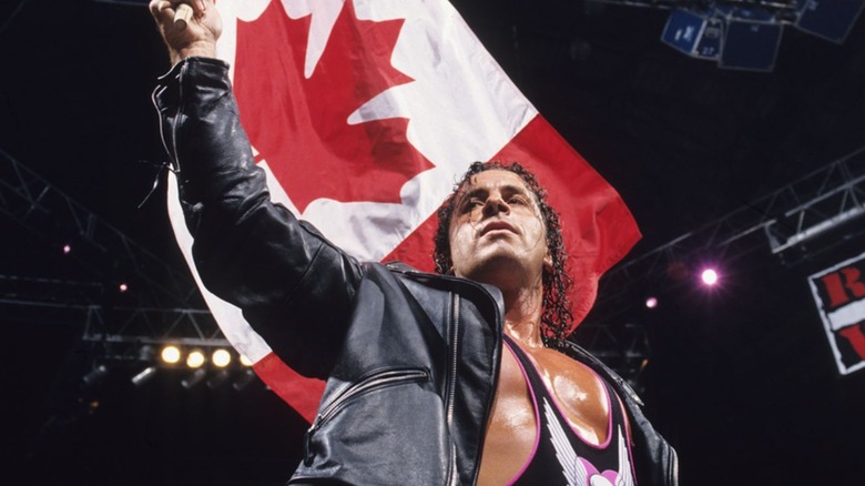 Bret Hart holds up a Canadian flag in the ring during an episode of "Monday Night Raw."