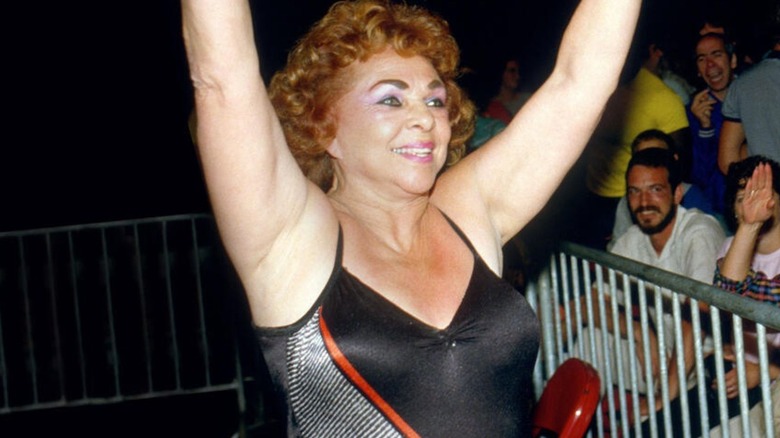 Fabulous Moolah poses for the crowd while heading down to the ring for a match.
