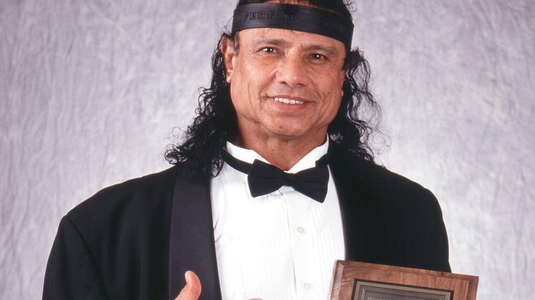 Jimmy Snuka poses backstage with a plaque honoring him in 1996.