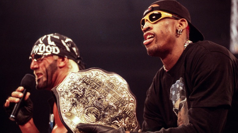 Dennis Rodman holding the WCW World Heavyweight Championship beside Hulk Hogan