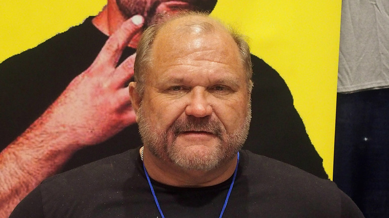 Arn Anderson stands in front of an Arn Anderson poster