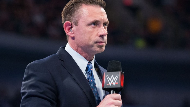 WWE commentator Michael Cole holding a microphone