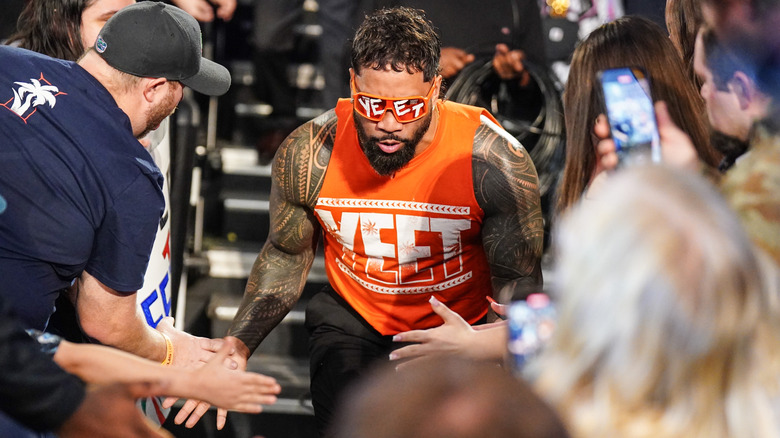 Jey Uso slaps the fan's hands as he makes his way to the ring