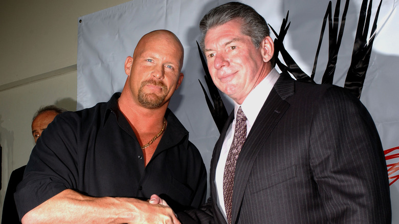 Stone Cold Steve Austin shakes hands with Vince McMahon