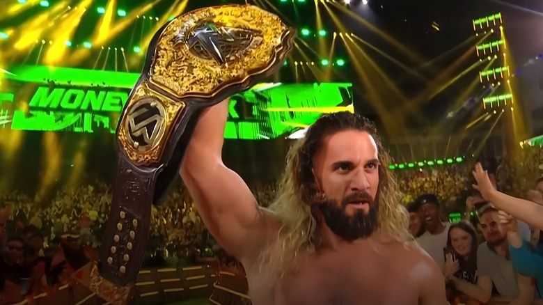 Seth Rollins holds up his title