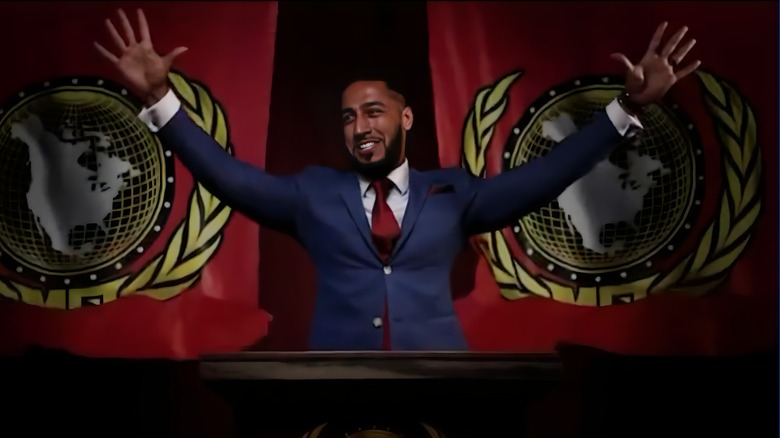 Mustafa Ali raises his arms at a podium