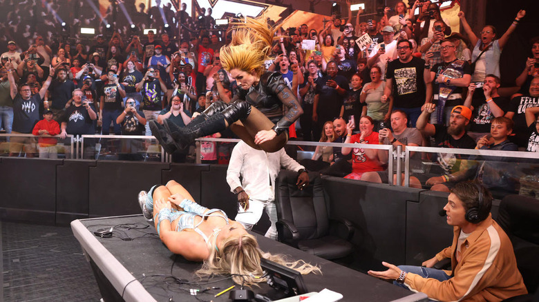 Becky Lynch leg drops Tiffany Stratton on a table