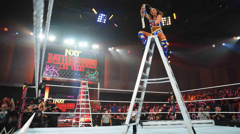 Kelani Jordan sitting on ladder raising title