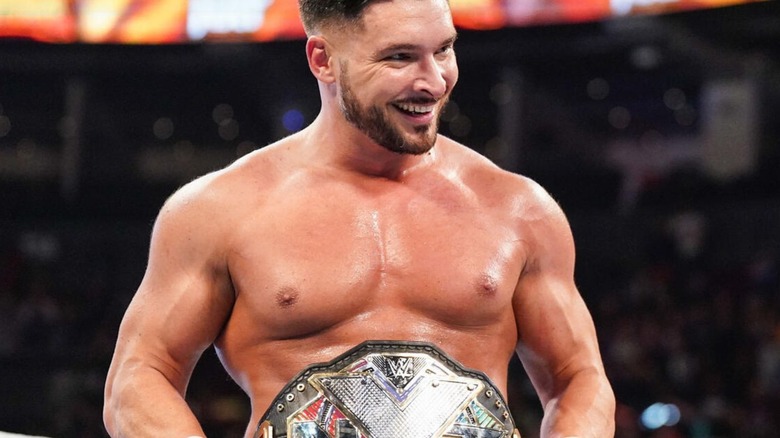 Ethan Page poses for the crowd with the NXT Championship around his waist in the ring during an episode of "WWE NXT" programming.