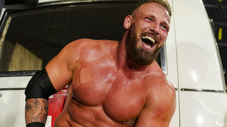 Ridge Holland laughs while sitting in front of an ambulance at "WWE NXT" Halloween Havoc.