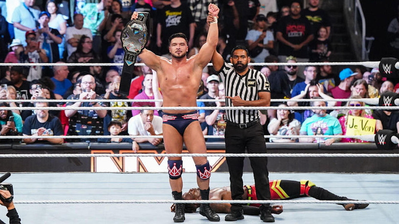 Ethan Page raises the NXT title above a prone Je'Von Evans