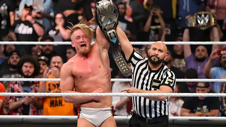 Ilja Dragunov raises the NXT Championship belt