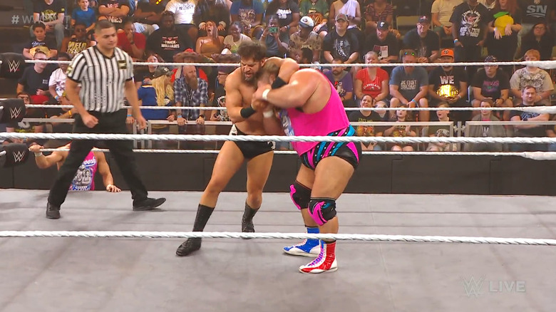 Gulak with a side headlock cinched in on Otis