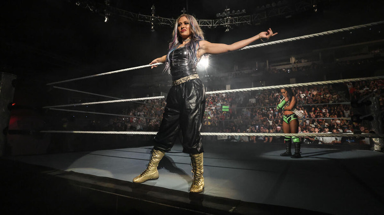 Giulia stands on the ring apron with Roxanne Perez behind her