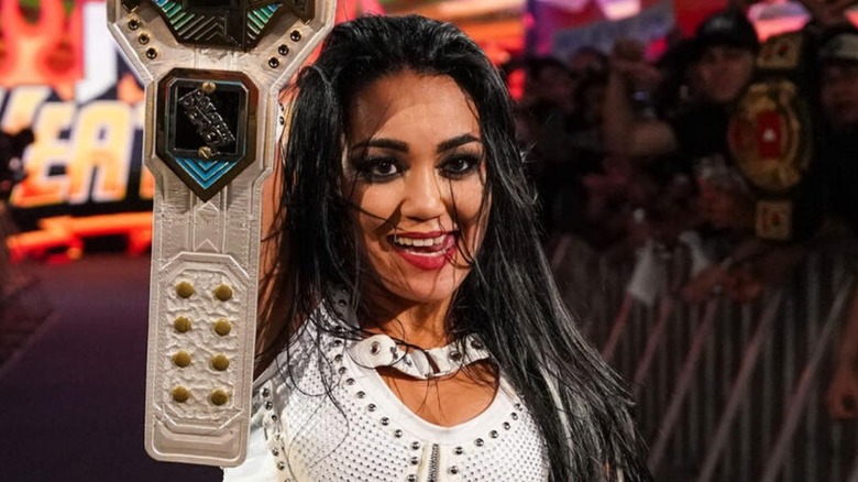 NXT Women's Champion Roxanne Perez stands with her championship in the air