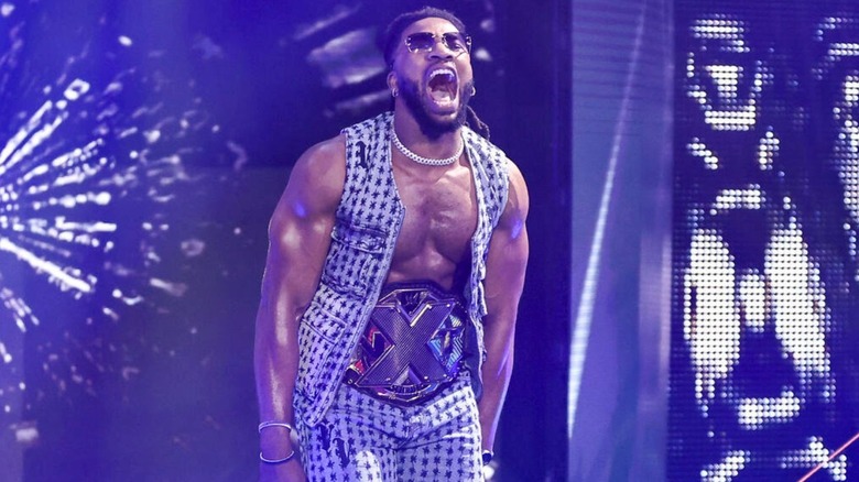 Trick Williams stands on the stage, wearing his NXT Championship, ahead of a segment on "WWE NXT."