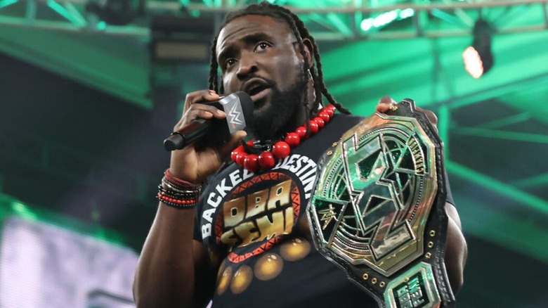 NXT Champion Oba Femi holds up his title while cutting a promo in the ring on "WWE NXT."