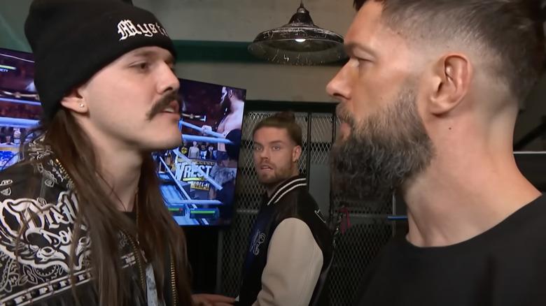 Dominik Mysterio faces off with Finn Balor backstage on "WWE Raw" while JD McDonagh looks on.