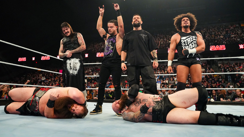 The Judgment Day gloating over the fallen War Raiders in the ring on "WWE Raw."