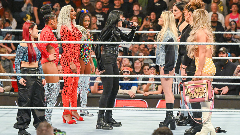 Rhea Ripley stands with babyface WarGames team, yells into microphone at heel WarGames team on "WWE Raw."