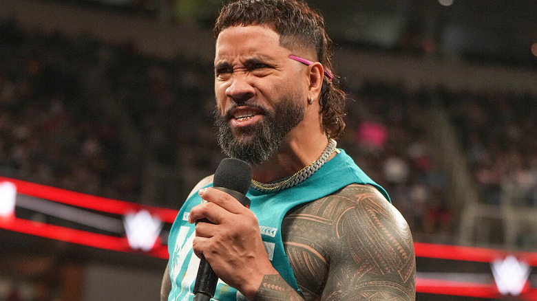 Jey Uso emotes while speaking into the microphone on "WWE Raw"