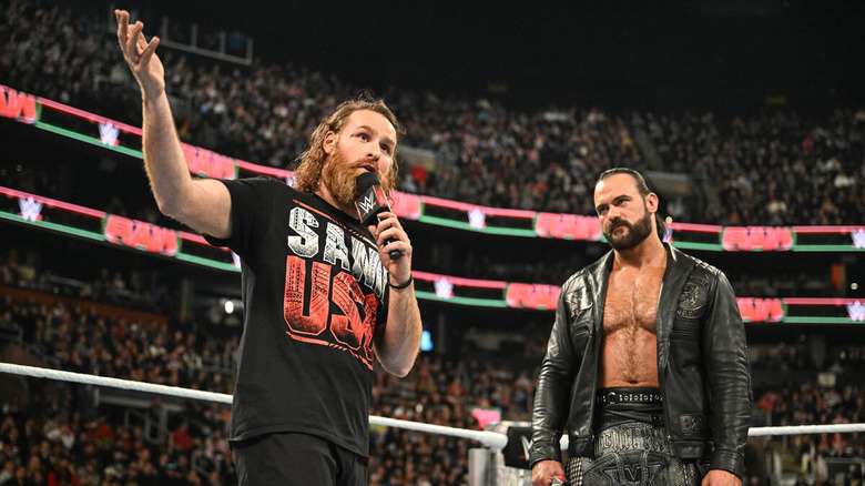 Sami Zayn gestures while talking to Drew McIntyre on the microphone in the ring on "WWE Raw."