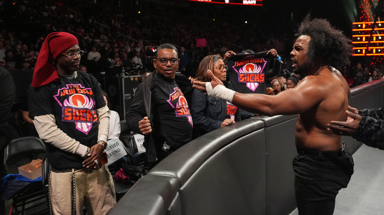 Xavier Woods confronts his family in the front row wearing "New Day Sucks" shirts on "WWE Raw"