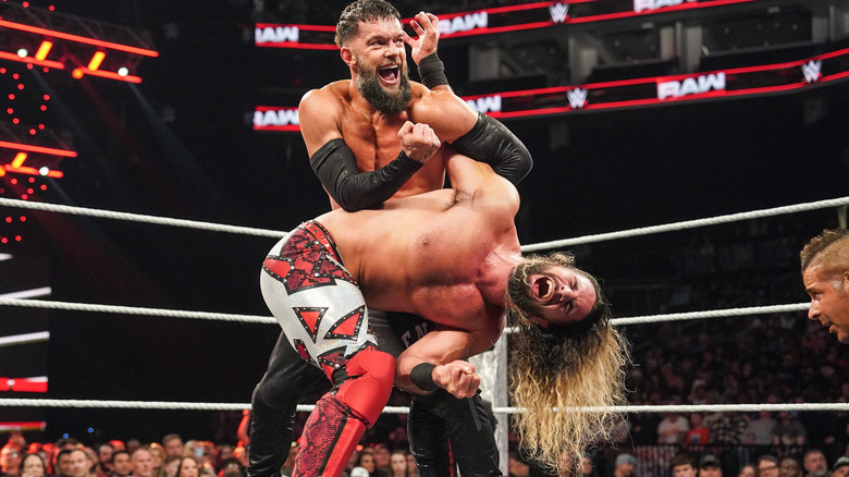 Finn Balor with a submission hold on Seth Rollins