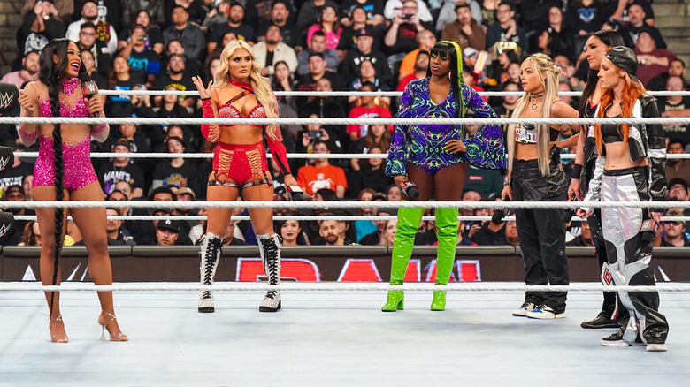 Bianca Belair in the ring with Tiffany Stratton, Naomi, Liv Morgan, Raquel Rodriguez, and Becky Lynch