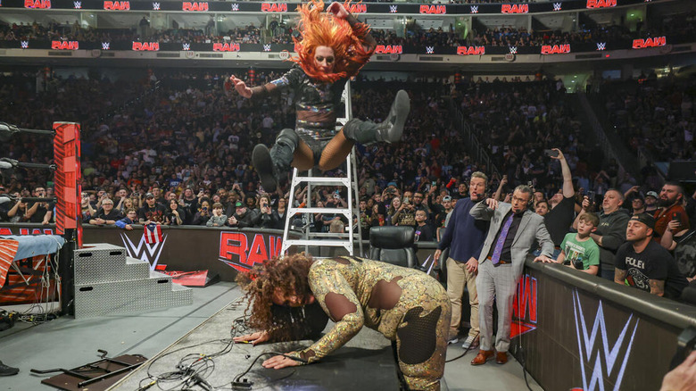 Becky Lynch legdrops Nia Jax off a ladder through a table
