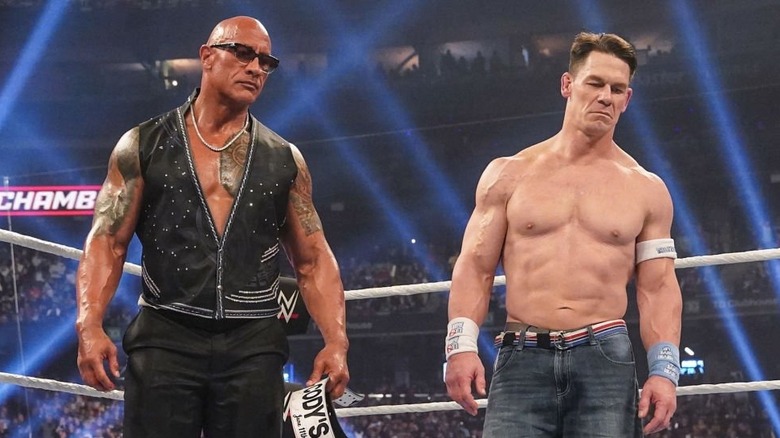 Dwayne "The Rock" Johnson and John Cena stare down, scowling.