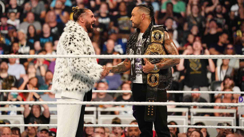 Seth Rollins shakes hands with Damian Priest