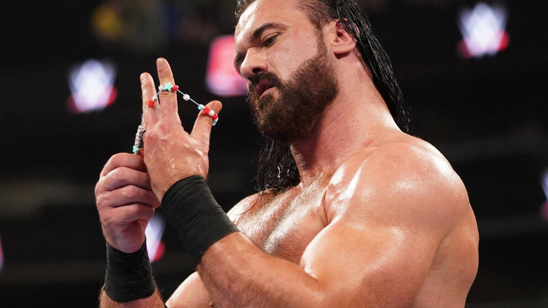 Drew McIntyre looks at CM Punk's bracelet