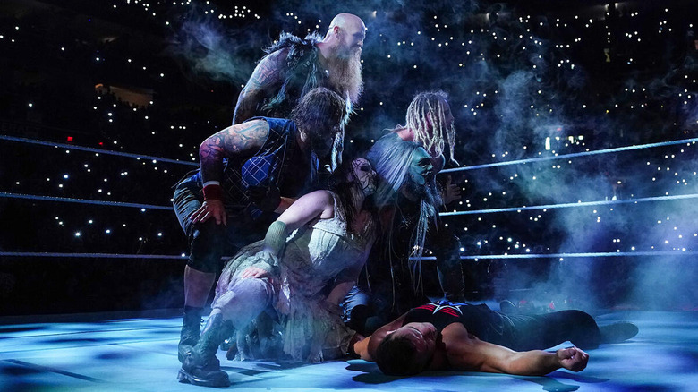 The Wyatt Sicks pose over Chad Gable