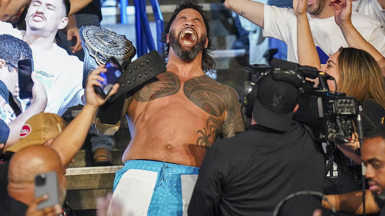 Jey Uso screams in the crowd while holding Intercontinental title