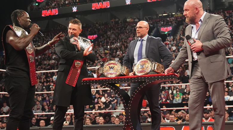 R-Truth and the Miz, Awesome-Truth, are presented with new WWE World Tag-Team Championships by Triple H and Adam Pearce