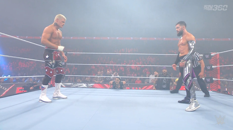 Rhodes and Balor staring one another down