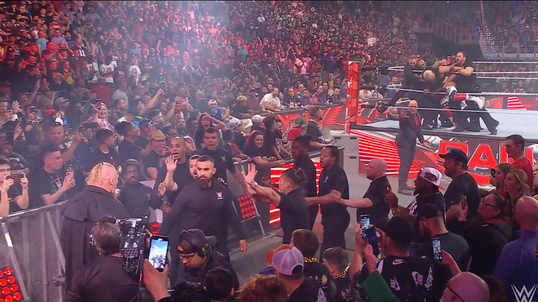 Lesnar and Rhodes being held back by security