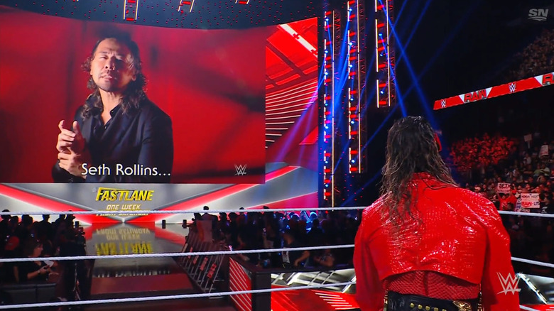 Nakamura giving a message to Rollins