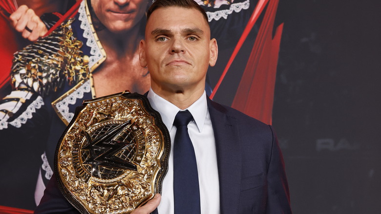 GUNTHER holding world title on his shoulder while wearing a suit at "WWE Raw" Netflix premiere