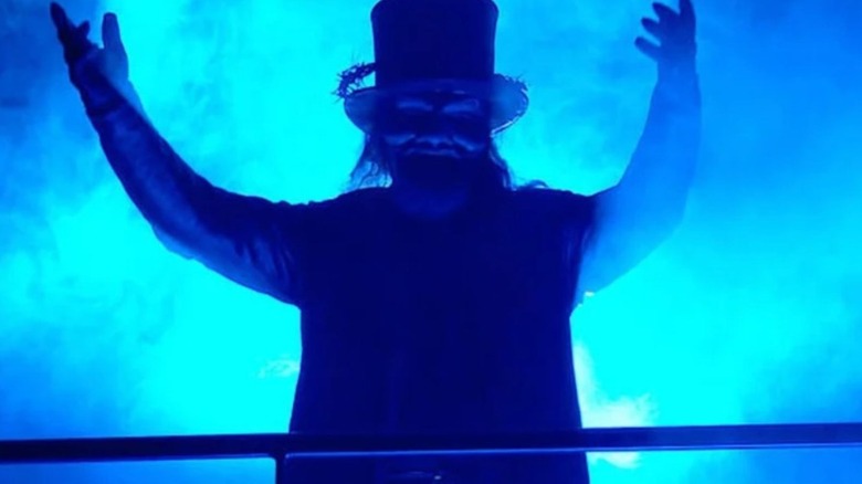 Uncle Howdy raises his arms while making an appearance in the crowd during an episode of "WWE SmackDown."