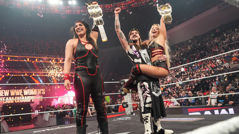 Raquel Rodriguez and Liv Morgan celebrate their title win with Dominik Mysterio