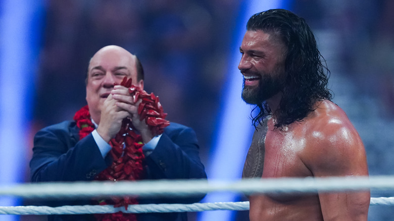 Roman Reigns laughing in WWE ring with Paul Heyman