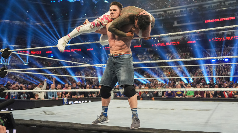 John Cena stands on the ring apron with Jey Uso on his shoulders at WWE Royal Rumble.