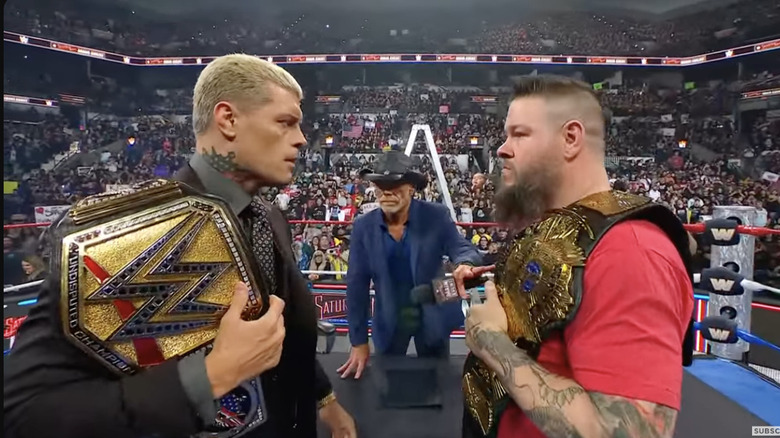 Rhodes and Owens staring each other down inside the ring