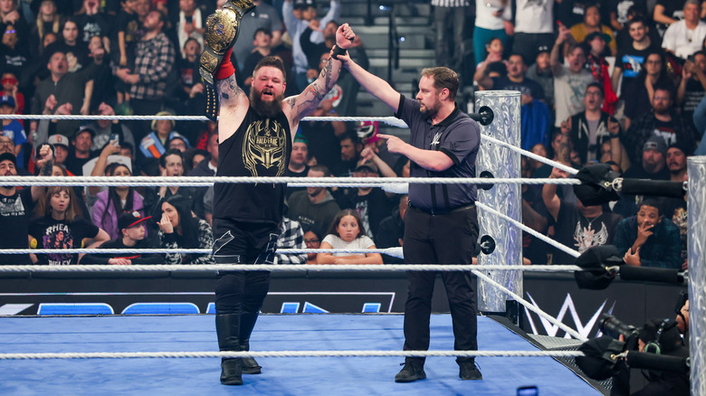 Kevin Owens raises the winged eagle title as the referee raises his arm on "WWE SmackDown."